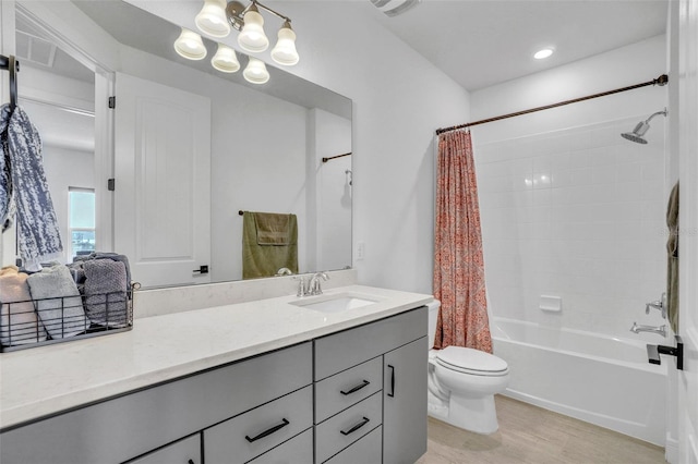 bathroom featuring wood finished floors, toilet, vanity, and shower / bath combo