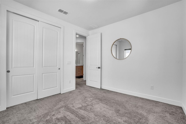 unfurnished bedroom with a closet, visible vents, baseboards, and carpet