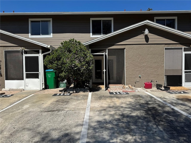 exterior space featuring stucco siding and uncovered parking