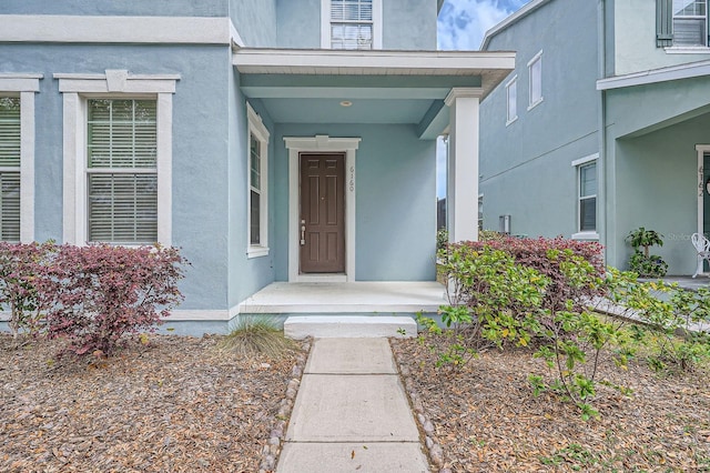 doorway to property featuring stucco siding