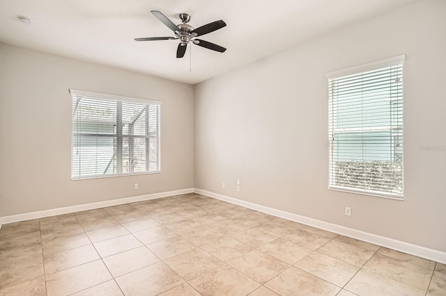 spare room featuring light tile patterned flooring, baseboards, and a ceiling fan