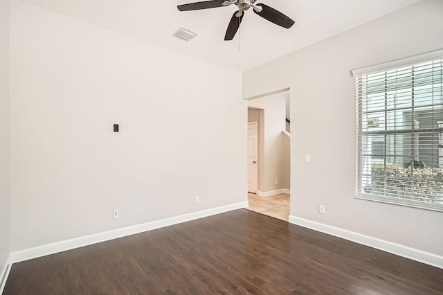 unfurnished room with visible vents, wood finished floors, baseboards, and ceiling fan