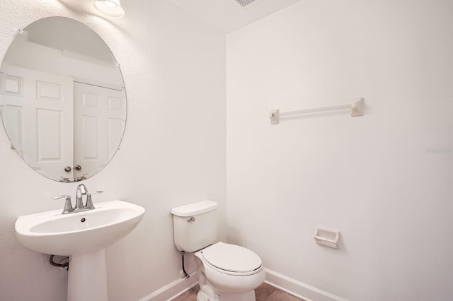 bathroom with toilet and baseboards