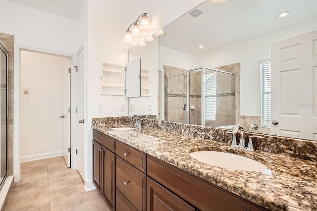 bathroom featuring a shower stall, double vanity, visible vents, and a sink