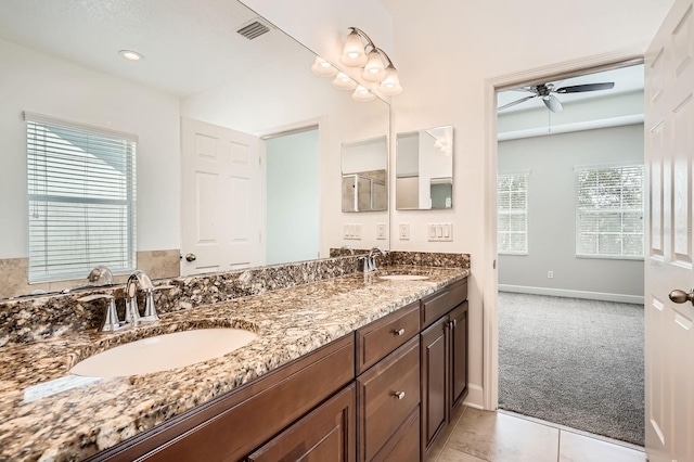 full bath with double vanity, a ceiling fan, visible vents, and a sink