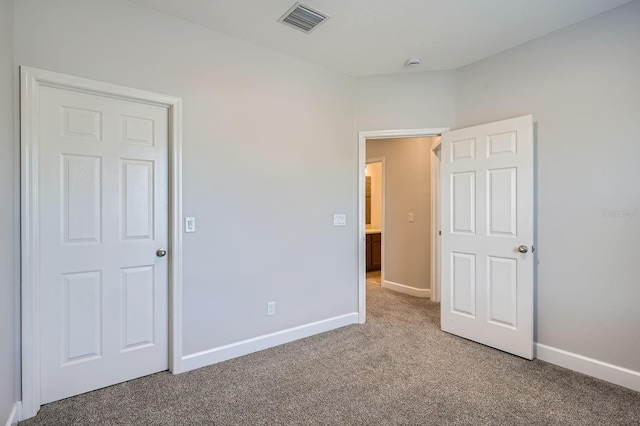 unfurnished bedroom with visible vents, carpet, and baseboards