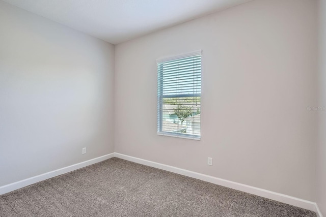 carpeted empty room with baseboards