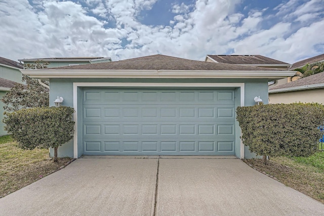 garage featuring concrete driveway