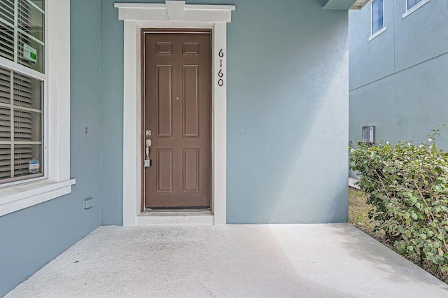 property entrance with stucco siding