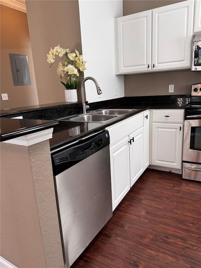 kitchen with a sink, stainless steel appliances, white cabinets, and dark wood-style flooring