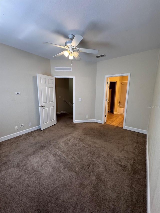 unfurnished bedroom with visible vents, ensuite bath, baseboards, and carpet floors