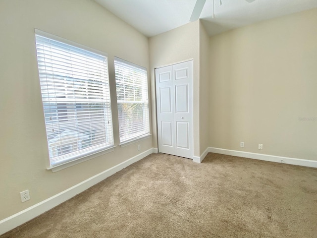 unfurnished bedroom with baseboards, carpet floors, and a closet