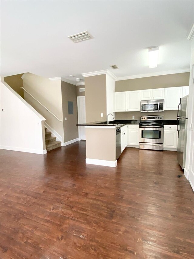 kitchen featuring a peninsula, dark countertops, visible vents, and stainless steel appliances