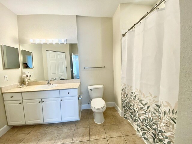 bathroom featuring tile patterned flooring, toilet, vanity, and baseboards