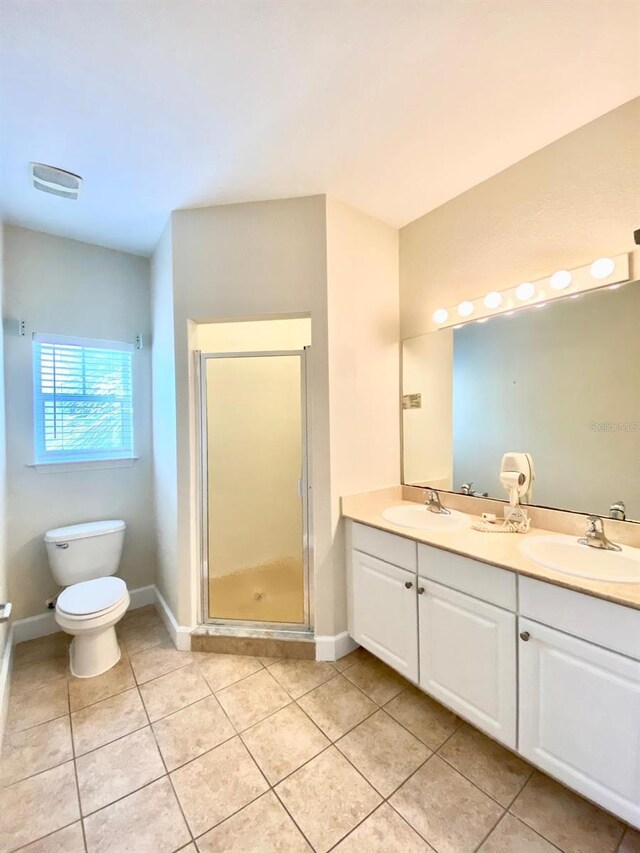 full bathroom featuring a sink, toilet, a stall shower, and double vanity