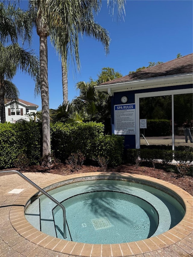 view of swimming pool featuring a hot tub