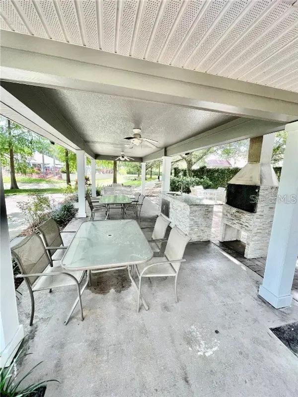 view of patio featuring an outdoor kitchen, outdoor dining area, and a ceiling fan