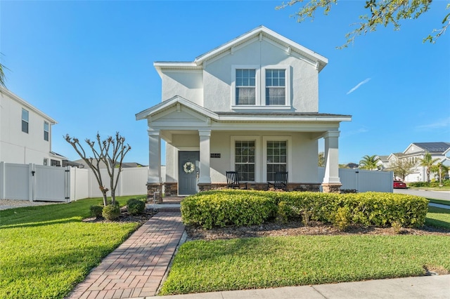 view of front of house featuring a gate, fence, a porch, stucco siding, and a front lawn