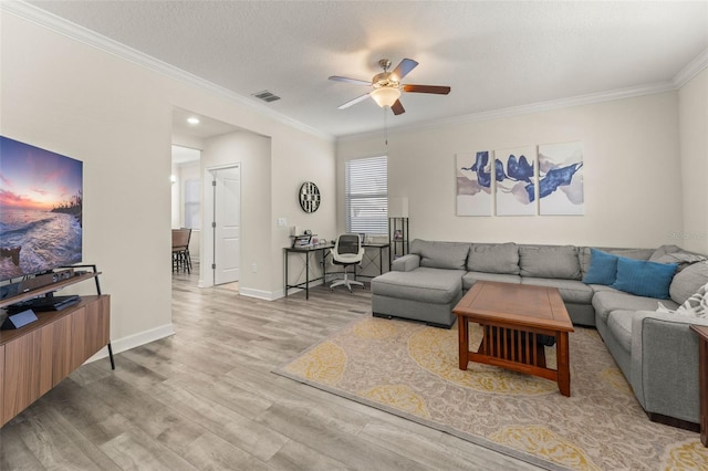 living area with visible vents, ornamental molding, a textured ceiling, wood finished floors, and baseboards