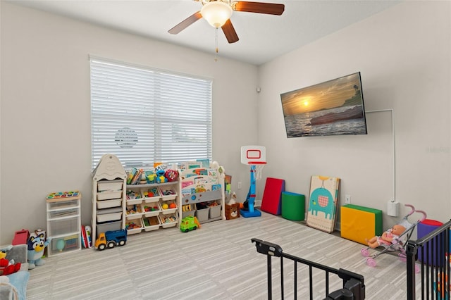 recreation room with a ceiling fan and carpet flooring