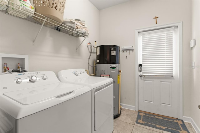 clothes washing area featuring independent washer and dryer, light tile patterned floors, baseboards, laundry area, and hybrid water heater