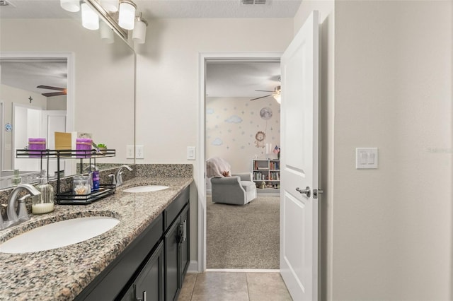 bathroom with a sink, visible vents, double vanity, and tile patterned floors