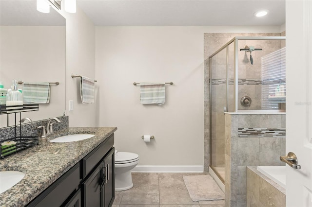 bathroom featuring toilet, baseboards, a stall shower, and a sink