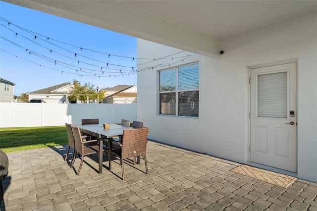 view of patio featuring outdoor dining area and fence