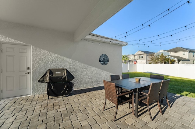 view of patio / terrace featuring outdoor dining area, fence, a residential view, and a grill