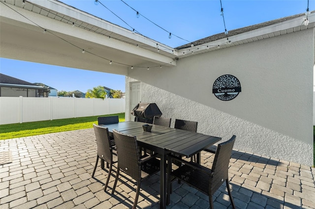 view of patio / terrace with a grill, outdoor dining area, and fence