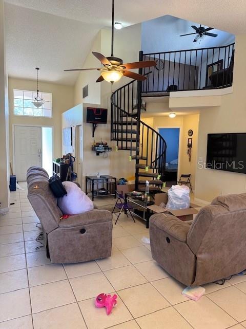 tiled living area with high vaulted ceiling, visible vents, and ceiling fan