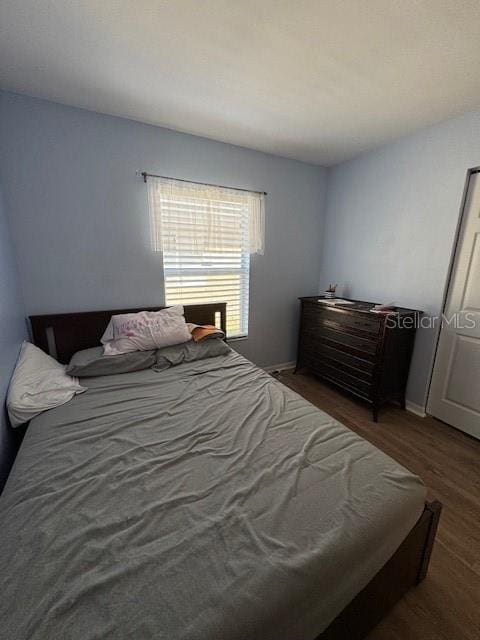 bedroom featuring baseboards and wood finished floors