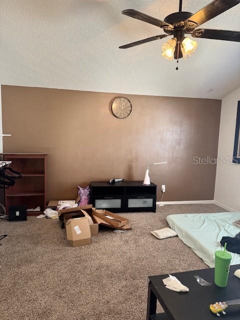 carpeted living room with a textured ceiling and a ceiling fan