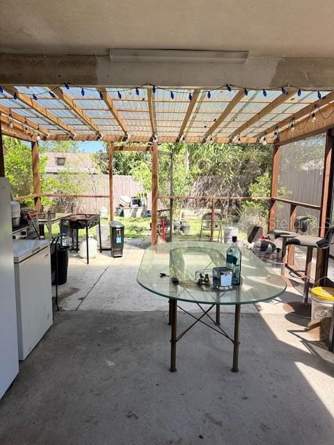 view of patio with outdoor dining area, fence, and a pergola