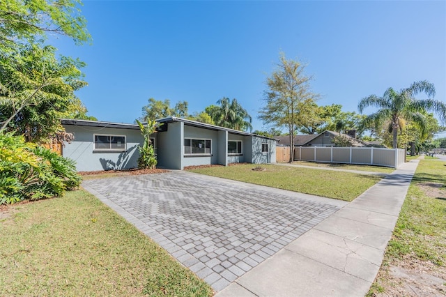 view of front of home featuring stucco siding, a front lawn, and fence