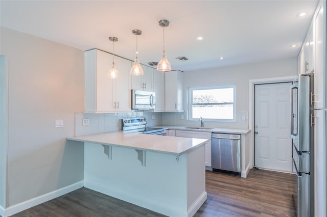 kitchen with visible vents, a sink, tasteful backsplash, stainless steel appliances, and a peninsula