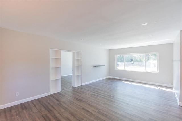 unfurnished room with baseboards and wood finished floors