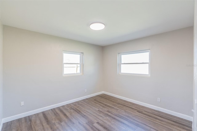 empty room featuring baseboards and wood finished floors