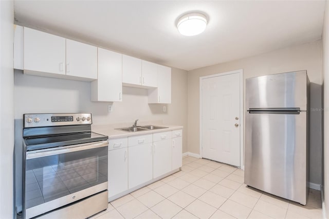 kitchen with a sink, appliances with stainless steel finishes, white cabinets, light countertops, and light tile patterned floors