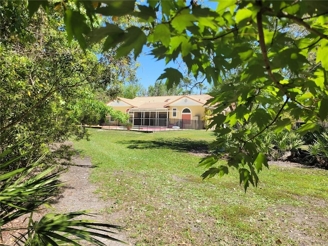 view of yard featuring fence and a sunroom