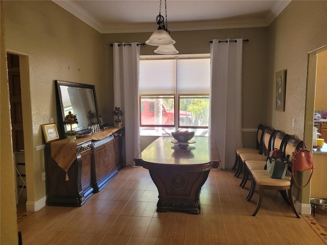 dining room featuring crown molding, baseboards, and light wood-type flooring