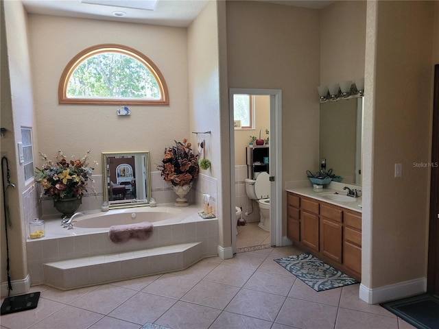 bathroom with tile patterned flooring, vanity, toilet, and a bath