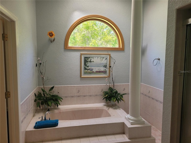 bathroom with a garden tub and a textured wall