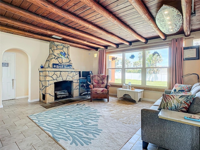 living area featuring wooden ceiling, a fireplace, arched walkways, and baseboards