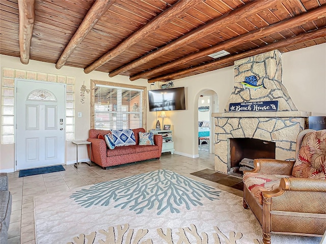 tiled living area with arched walkways, beam ceiling, a fireplace, and wood ceiling