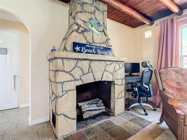 interior details featuring baseboards, beamed ceiling, wooden ceiling, a fireplace, and arched walkways