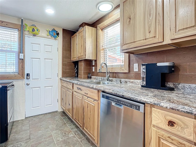 kitchen featuring light brown cabinets, decorative backsplash, appliances with stainless steel finishes, a textured ceiling, and a sink