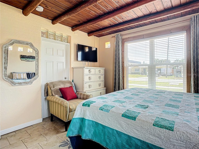 bedroom with light tile patterned floors, beamed ceiling, wood ceiling, and baseboards