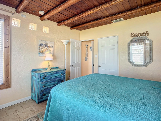 bedroom with beam ceiling, wood ceiling, baseboards, and a textured wall