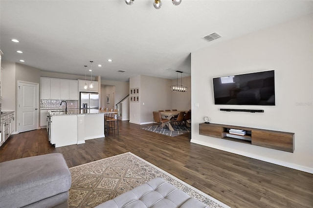 living room with recessed lighting, visible vents, baseboards, and dark wood-type flooring